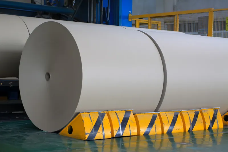 Large rolls of laminated material on a production floor